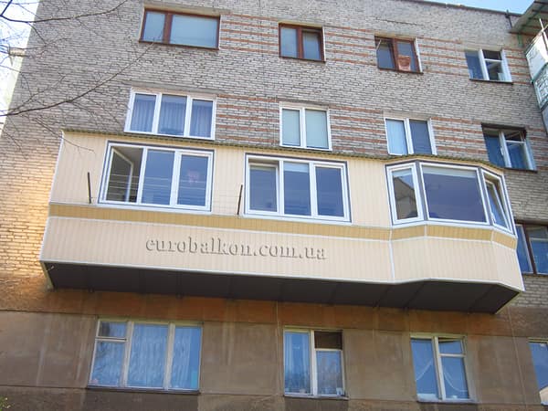 Кутовий балкон з бежевим профнастилом та панорамним заскленням